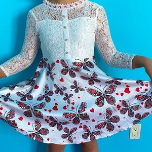 White lace dress skirted with red butterflies.